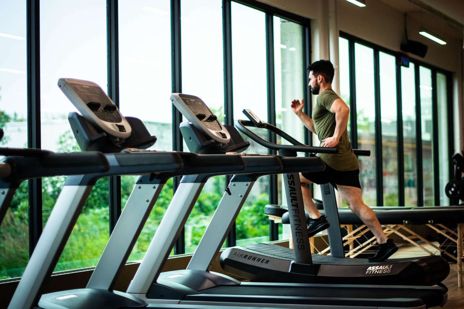 Fitness room with cardio equipment beside floor to ceiling windows